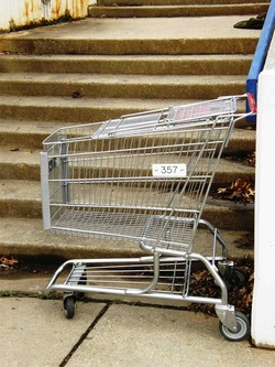 Photograph of a shopping trolley stranded at the bottom of a flight of stairs.